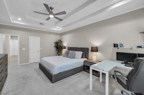a bedroom with a bed and a desk with a computer at The Tulsacation on Oxford in Tulsa