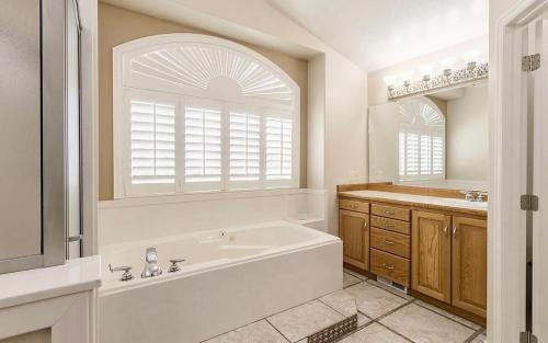 a white bathroom with a tub and a sink at Fossil Crest Retreat in Vernal