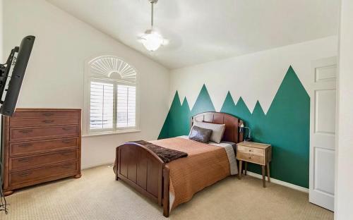a bedroom with a bed with a green accent wall at Fossil Crest Retreat in Vernal