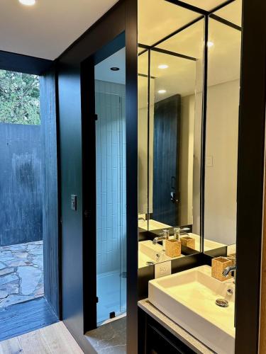 a bathroom with two sinks and a large mirror at Camp Cold Springs in Concan