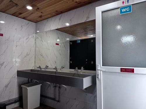 a bathroom with a sink and a large mirror at Albergue Santiago de Caminha in Caminha