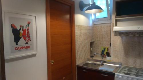a kitchen with a sink and a picture of aanchez at Propaganda Room in Albano Laziale
