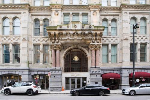 a large building with cars parked in front of it at Downtown Luxe 2BR Loft Apt | Prime Location | Sleeps 10 in Milwaukee
