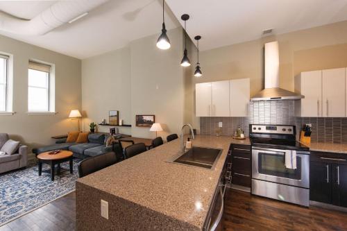 a kitchen and living room with a couch and a table at Downtown Luxe 2BR Loft Apt | Prime Location | Sleeps 10 in Milwaukee