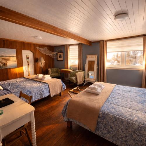 a hotel room with two beds and a table at Gite de la Baie Hatée in Bic