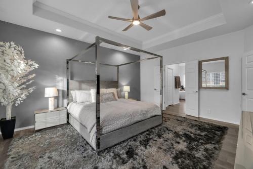 a bedroom with a canopy bed and a ceiling fan at The Tulsacation 2 in Tulsa