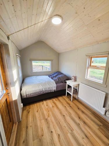 a bedroom with a bed in a tiny house at Northern Lights Cabin - Syribr in Grímsnes og Grafningshreppur