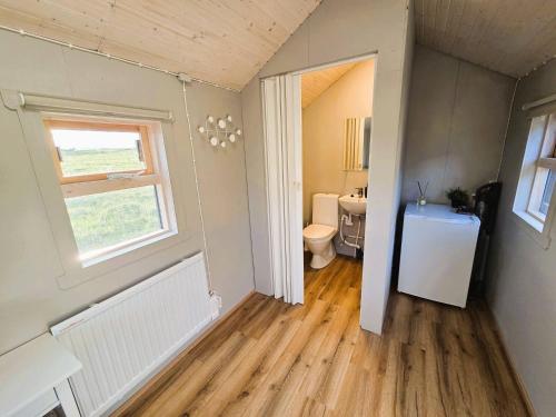 an empty bathroom with a toilet and a window at Northern Lights Cabin - Syribr in Grímsnes og Grafningshreppur