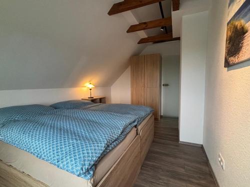 a bedroom with a bed with a blue comforter at Huus Diekblick Ditzum in Bunde