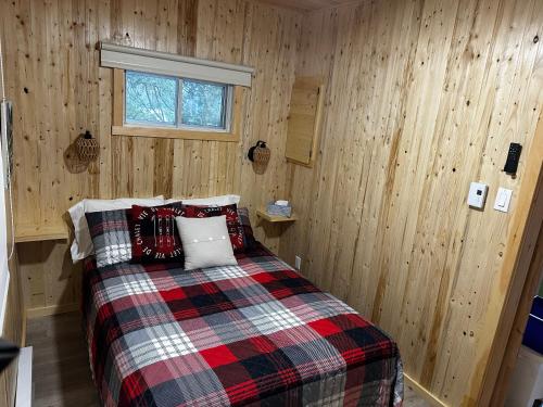 a bedroom with a bed with a plaid blanket at Chalet memphrémagog - 203 in Magog-Orford