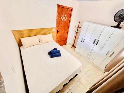 a bedroom with a white bed and a refrigerator at Refúgio da Serra - Apto Completo a 3 minutos do centro de Canela in Canela