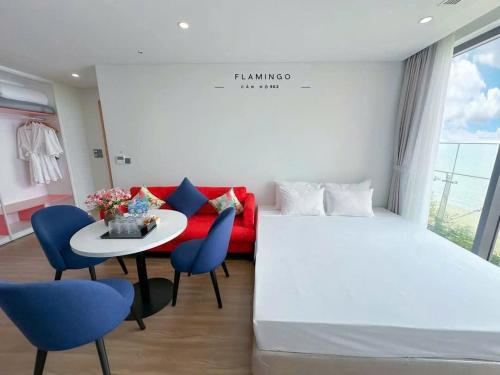 a hotel room with a bed and a table and chairs at Flamingo Hai Tien Beach Resort in Thanh Hóa