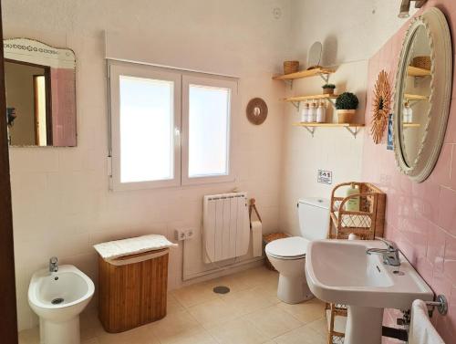a bathroom with a sink and a toilet and a mirror at Casa Terra in Hontanar