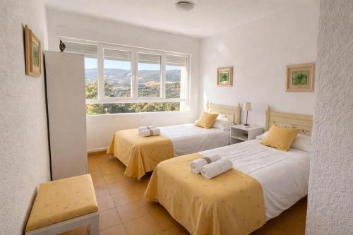 two beds in a room with a window at Casa Terra in Hontanar