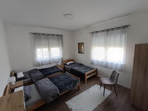 a bedroom with two beds and a desk and a chair at MORLAK - Guest House - Restaurant - Gated parking in Polača