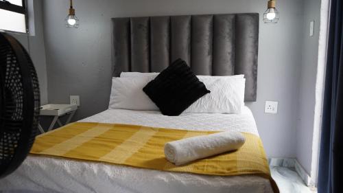 a bed with a yellow and white blanket and pillows at Precious Guest House in Manamakgoteng