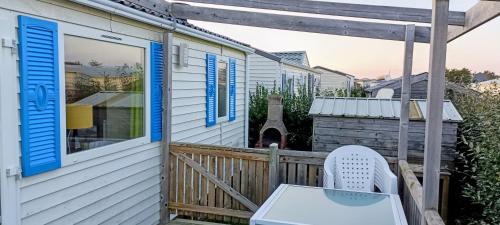 a porch with a chair and a house at Mobile Home privé dans camping n 69 in Port-Bail-sur-Mer