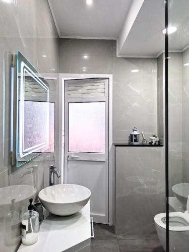 a white bathroom with two sinks and a toilet at Edion Center Apartment in Shkodër