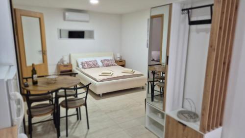 a bedroom with a bed and a table and chairs at Maras studio apartmani, Vinkovci in Vinkovci