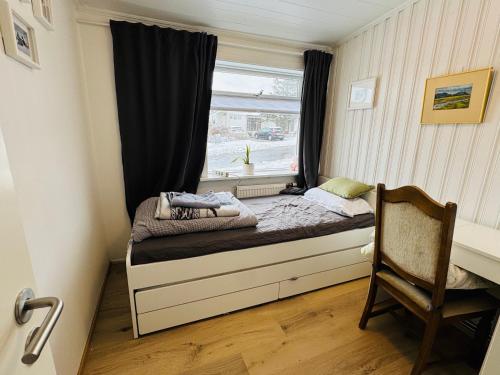 a small bed in a small room with a window at Langafit Guest house in Garðabær