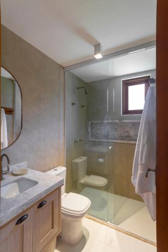 a bathroom with a toilet and a glass shower at Diamantino Residence - Barro in Mucugê