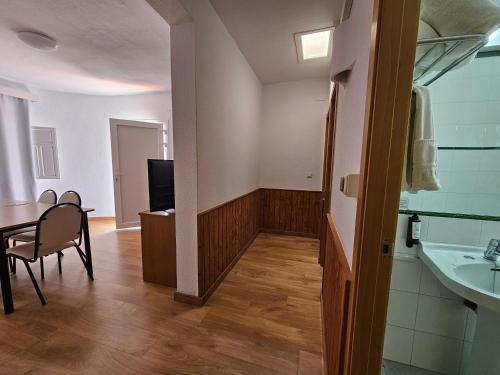 a bathroom with a sink and a table and a chair at Hotel Puntazo II in Mojácar