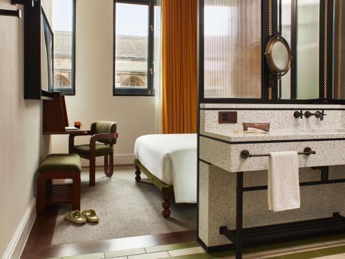 a hotel room with a bathroom with a bed and a sink at Hyde London City - St Paul's in London