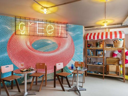 a restaurant with a mural of a surfboard on the wall at Greet Hotel Nice Aéroport Promenade des Anglais in Nice