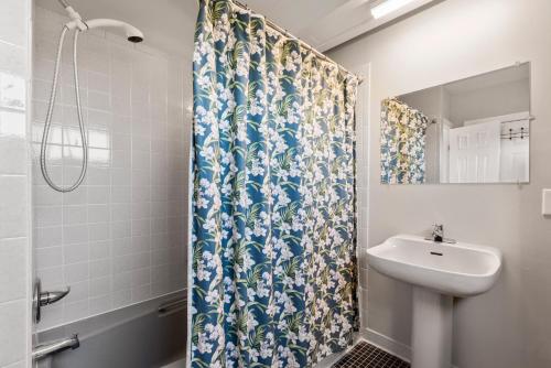 a bathroom with a shower curtain and a sink at Crabcake Village OBX in Salvo