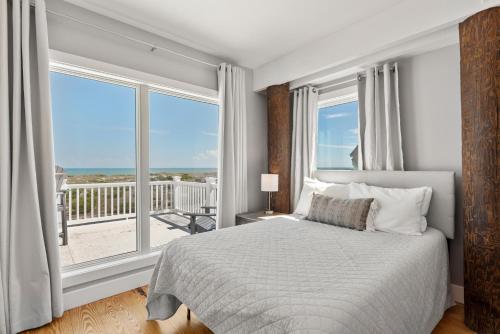 a bedroom with a bed and a large window at Crabcake Village OBX in Salvo