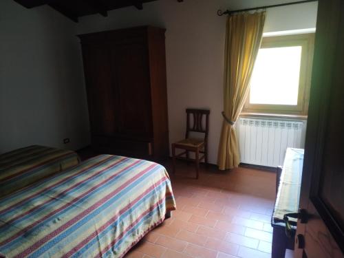 a bedroom with a bed and a window and a chair at Agriturismo Il Conventino in Vallicchio
