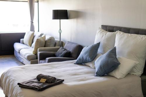 a hotel room with a bed and a couch at Onyx Studio Apartment in Cape Town