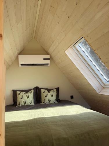 a bedroom with a bed in the attic with a window at Uduaasa Minimaja in Urge