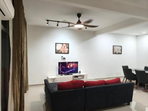 a living room with a couch and a flat screen tv at Atabara ECRL Stay Homestay in Kuantan