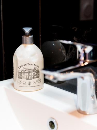 a bottle of soap sitting on top of a sink at 2 Chambres - 150m plage - Centre & Marché 50m - Parking - Linge & Menage inclus in Houlgate