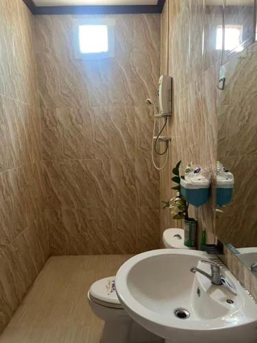 a bathroom with a sink and a toilet and a phone at FUBON World Hostel in Ban That-Louang