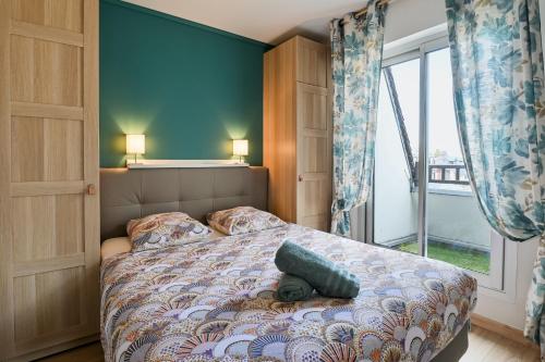 a bedroom with a bed and a large window at 2 Chambres - 150m plage - Centre & Marché 50m - Parking - Linge & Menage inclus in Houlgate