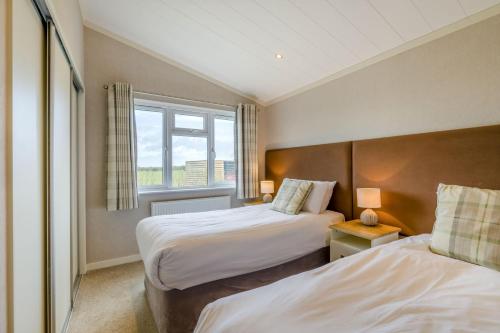 two beds in a hotel room with a window at Primrose 2 bed-No Pets-Daisy in Eye