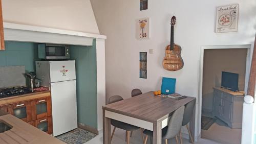 a kitchen with a table and a guitar on the wall at Ola Linda - Casa de Campo - in Castelo de Vide
