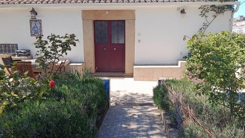 a red door on a white house with plants at Ola Linda - Casa de Campo - in Castelo de Vide