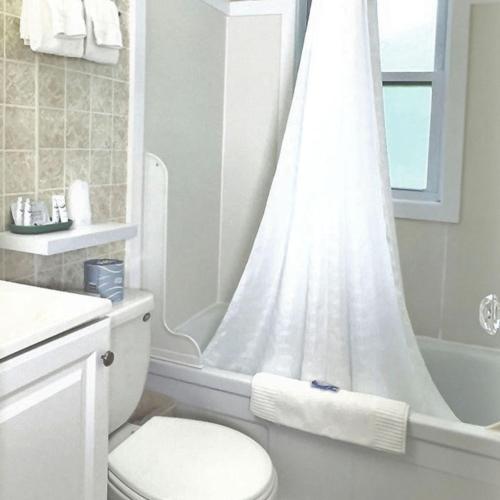a white bathroom with a shower and a toilet at Kennebunkport Motor Lodge in Kennebunkport