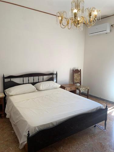 a bedroom with a large bed with a chandelier at La casa di Amina in Rome