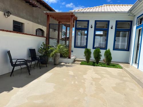 a patio with a table and chairs in front of a house at Casa BLUE Praça 102 in Carrancas