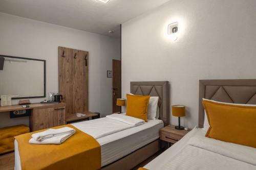 two beds in a room with yellow and white at Hotel Domestika in Skopje