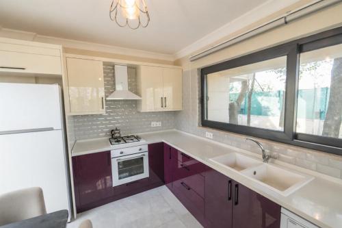 a kitchen with purple cabinets and a sink and a window at Villa Ana in Kızılyurd