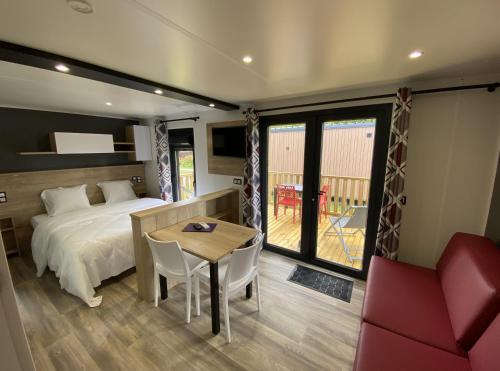 a bedroom with a bed and a table and a chair at Domaine Les Abberts in Arès