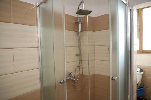 a shower with a glass door in a bathroom at Apartment Nikolas Berat in Berat