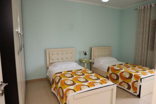 two beds sitting next to each other in a bedroom at Apartment Nikolas Berat in Berat