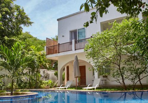 a villa with a swimming pool and a house at Alexanders Hotel in Dar es Salaam