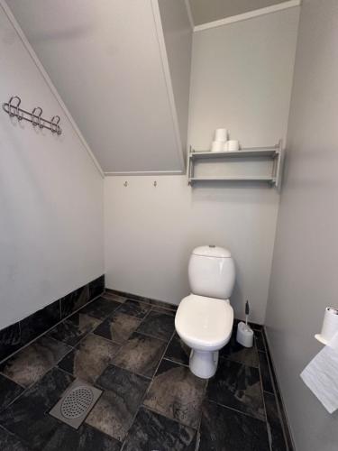 a bathroom with a toilet and a tile floor at Lysbøen Bua in Ramberg
